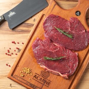 Quatro fatias frescas e suculentas de baby beef campinas dispostas sobre uma tábua de madeira artesanal na Ramalho Carnes.