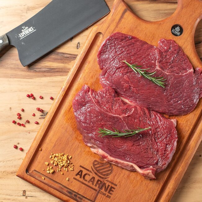 Quatro fatias frescas e suculentas de baby beef campinas dispostas sobre uma tábua de madeira artesanal na Ramalho Carnes.