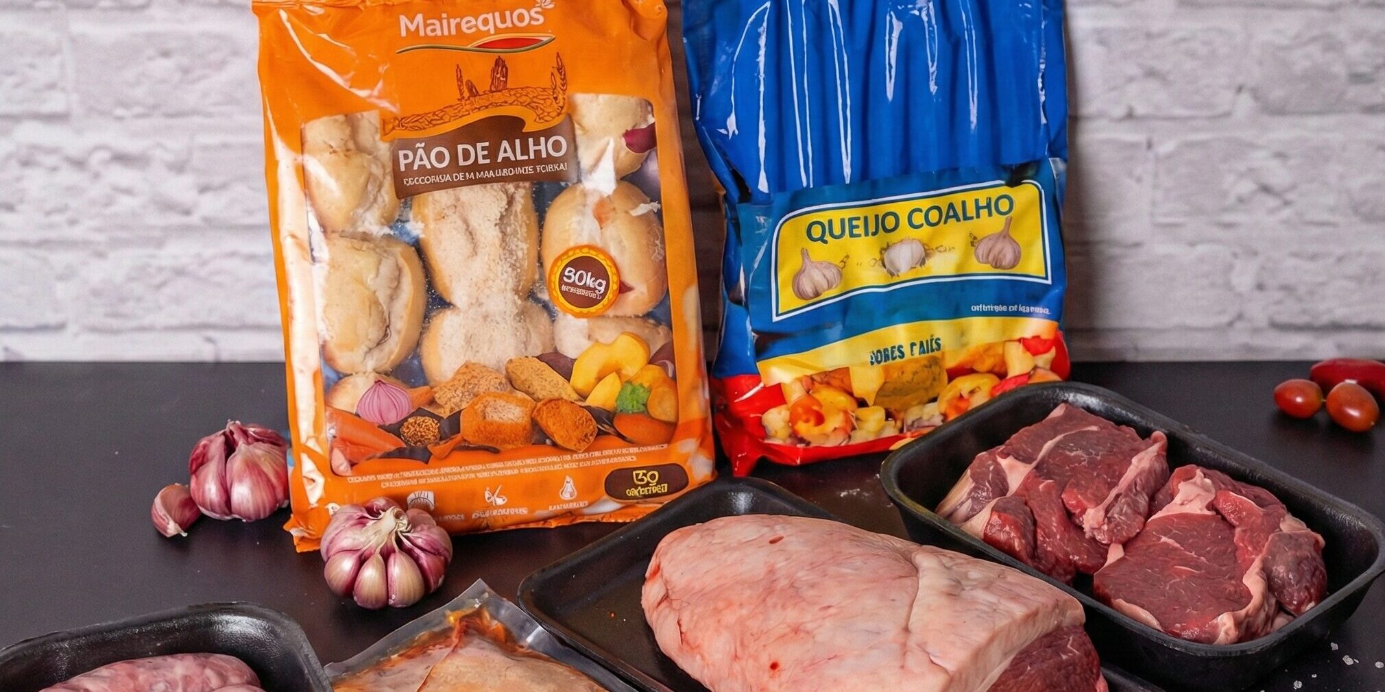 kit-churrasco-completo-ramalho-carnes Kit churrasco completo com picanha, linguiça, cortes de bife ancho, pão de alho e queijo coalho dispostos sobre uma mesa preta.