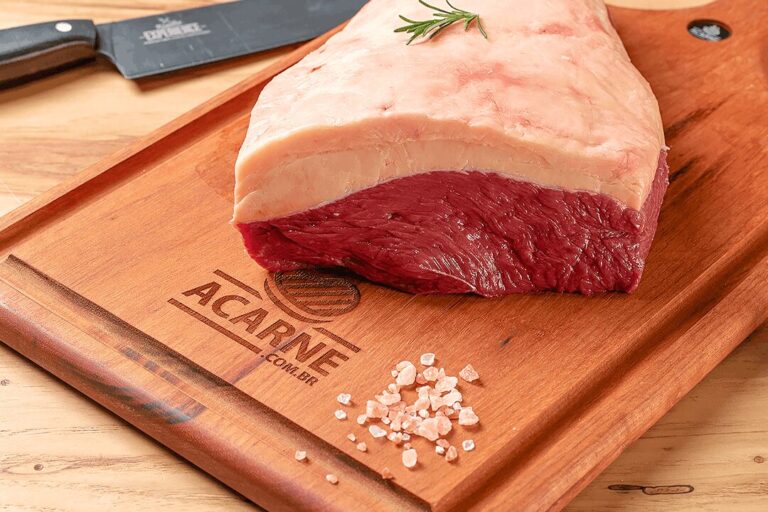 carne-boa-para-churrasco-guia-ramalho-carnes Picanha bovina premium com capa de gordura espessa e uniforme sobre tábua de madeira gravada com alecrim e sal rosa, uma verdadeira carne boa para churrasco.