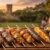 Linda tábua de madeira servindo diversos espetinhos prontos para churrasco, como carne, frango e queijo, com amigos confraternizando ao fundo durante o pôr do sol em Campinas.