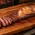 Fraldinha para churrasco assada inteira na tábua, com a capa de gordura dourada e as primeiras fatias mostrando o centro rosado